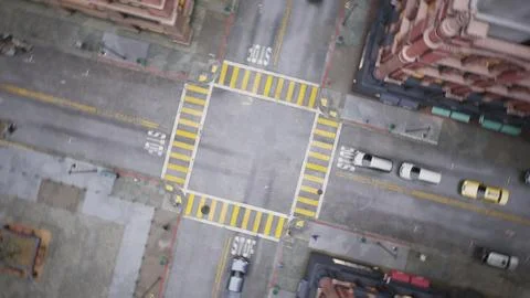 The camera, hovering over an intersection in a major business city, descends and Stock Photos