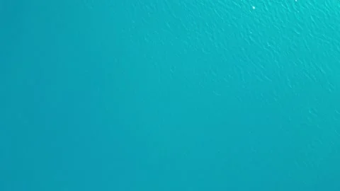 The camera hovers over the sea and looks down. Top-down view of blue sea waves Stock Footage 227937720