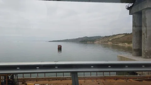 Camera inside the bus. The bus moves along the sea bridge, across the sea. 스톡 동영상 116277590