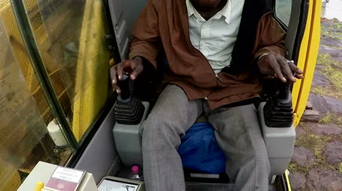 Camera inside the control cabin of a crane. The driver is of African ethnicity. Stock Footage 67383149