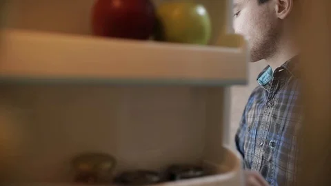 Camera inside the kitchen refrigerator. A young developer on isolation works Stock Footage 129152658