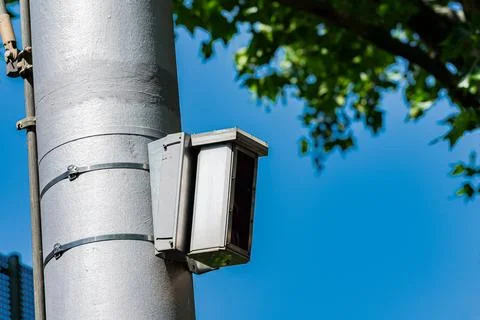 Camera installed on a pole captures street activity in daylight Stock Photos
