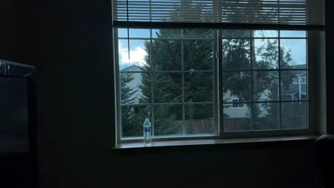 The camera jerkily moves closer to the window against the sky and Stock-Footage 233480265