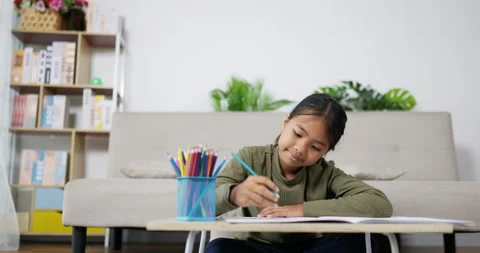 Camera from left to right. Happy asian girl drawing while sitting on floor  Video stock 201230495