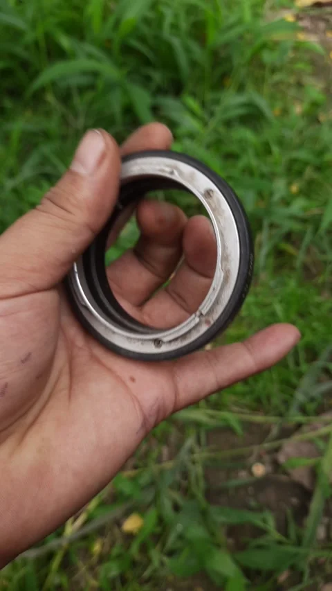Camera lens adapter ring, held in hands with metallic and rubber texture, o.. Stock Footage 345115906