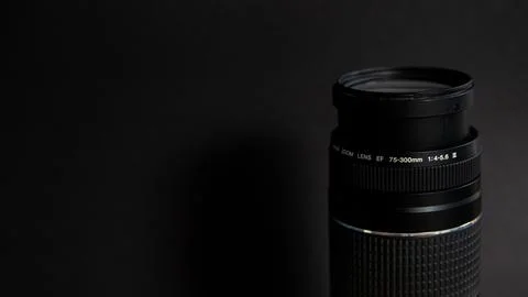 Camera lens on black background. Focus on lens. Shallow depth of field. Stock Photos