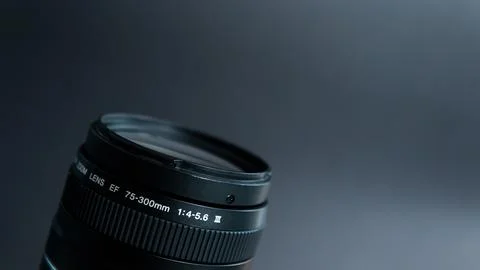 Camera lens on black background. Focus on lens. Shallow depth of field. Stock Photos