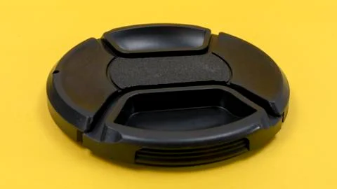 Camera lens cap on a yellow background Foto stock
