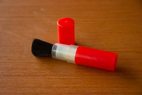 Camera lens cleaning pen placed on brown table Stock Photos