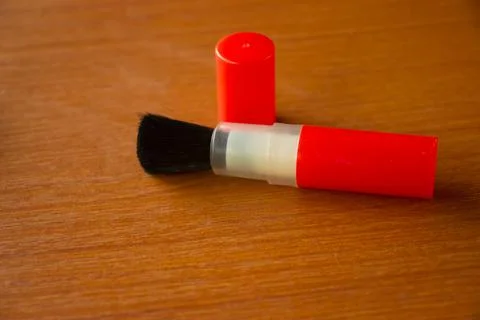 Camera lens cleaning pen placed on brown table Stock Photos