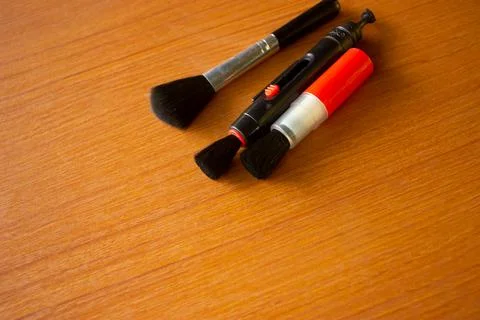 Camera lens cleaning pen placed on brown table Stock Photos