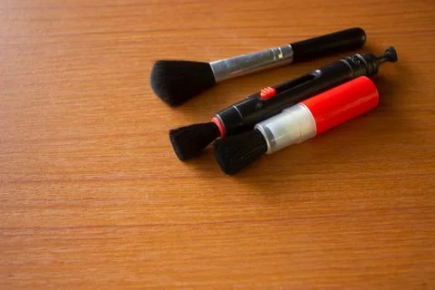Camera lens cleaning pen placed on brown table Foto stock
