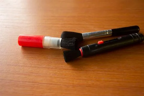 Camera lens cleaning pen placed on brown table Stock Photos