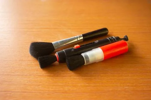 Camera lens cleaning pen placed on brown table Stock Photos