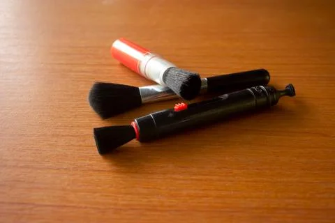 Camera lens cleaning pen placed on brown table Foto stock