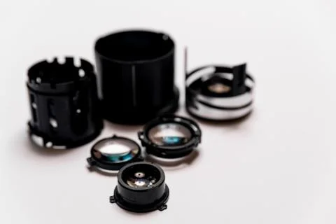 Camera lens disassembled. elements and pieces of lens glass lay on white back Stock Photos
