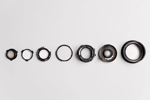 Camera lens disassembled. elements and pieces of lens glass lay on white back Stock Photos