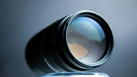 Camera lens on a gray background. Shallow depth of field. Stock Photos