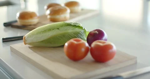 Camera lens shifting focus from tomatoes lettuce and onion to buns highlighting Stock Footage 343837587