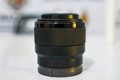 Camera lens on table with blurred background Stock Photos