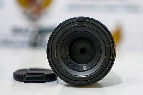 Camera lens on table with blurred background Stock Photos