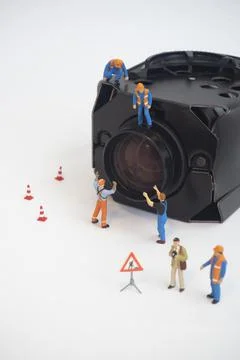 Camera lens with worker doing maintenance or installing. Stock Photos