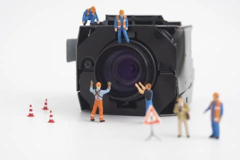 Camera lens with worker doing maintenance or installing. Stock Photos