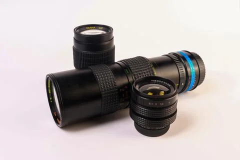 Camera lenses arranged in an angular layout on a soft white Stock Photos