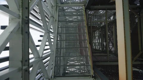 Camera looking down metal staircase inside industrial tower structure Stock Footage 344744796