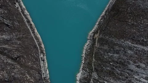 Camera looking down on the pale blue water of Laguna Paron panning up along  Stock Footage 252371913