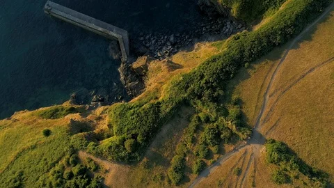 Camera looks down as drone descends to harbor wall Stock Footage 95828258