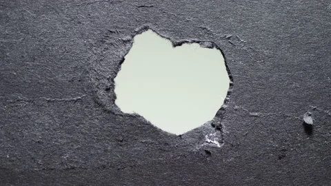 Camera looks through torn hole on thick black paper while light is moving. Stock Footage 135476641
