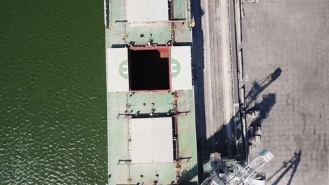 The camera looks vertically downward as it flies over a seagoing vessel moored i Stock Footage 155797561
