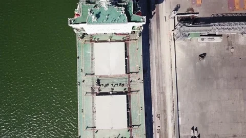 The camera looks vertically downward as it flies over a seagoing vessel moored i Vidéo 155800631