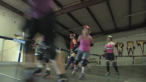 Camera low angle of skaters training around banked track, Texas Roller Derby Video stock 232958018