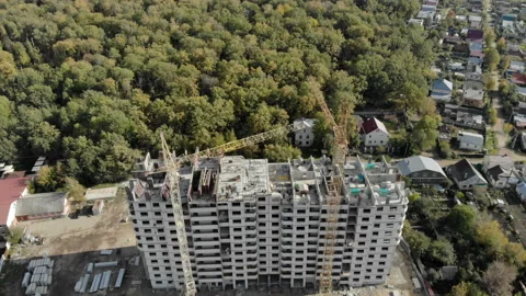 The camera is lowered over the construction of a high-rise building. Stock Footage 96352242