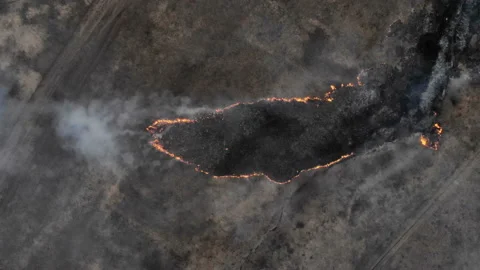 The camera is lowered onto a piece of burning field. Stock Footage 106381250