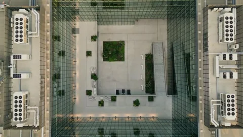 The camera is lowered into the well of a modern office building, courtyard. 動画素材 248636161