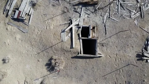 Camera lowers over the opening of an abandoned mine shaft Video stock 243699047