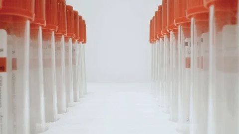 Camera with a macro lens moves past two rows of empty test jars Stock Footage 128232603