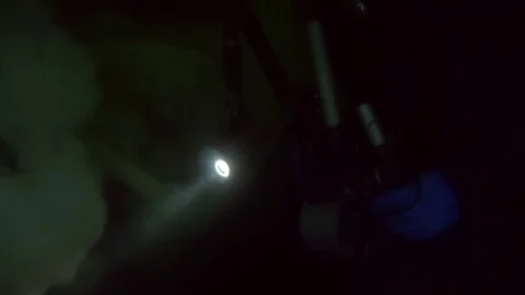 Camera man with flashlight on background seabed underwater in ocean of Alaska. Stock Footage