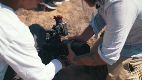 Camera man install lens in camera before filming in steppe. Stock Footage 318541738