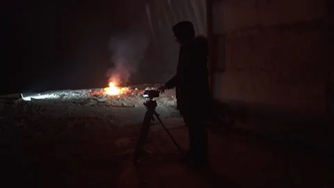 Camera man shoots a big fire in dark abandoned military hangar. Video stock 144673315