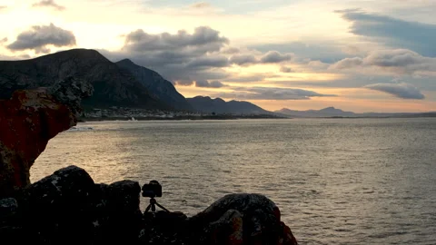 Camera on mini tripod on coastal cliff in Hermanus taking footage of sunrise Stockbeeldmateriaal 318604917