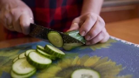 The camera monitors the blade of the knife while cutting cucumbers Stock Footage 123724646