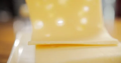 Camera in motion slice of cheese with holes falls on the board Stock Footage 120456652