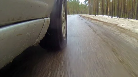 Camera mounted on a car when moving on winter road in forest. It goes sleet Stock Footage 71768362