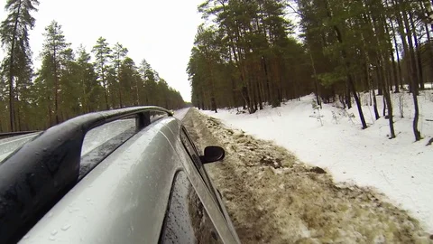 Camera mounted on a car when moving on winter road in forest. It goes sleet Stock Footage 71768792