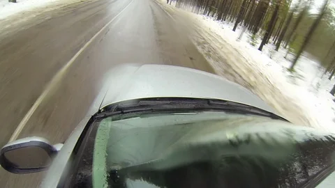 Camera mounted on a car when moving on winter road in forest. It goes sleet 動画素材 71769275