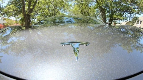 Camera mounted to front hood of a Tesla Model 3 showing chrome ornament. Stock Footage 109469222